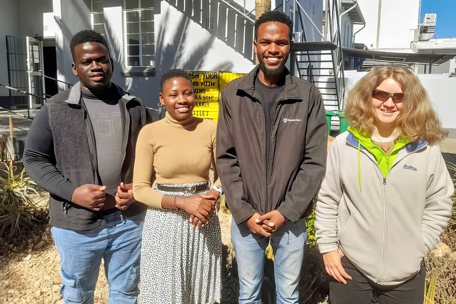 Two men and two women pose in the back garden of the NCE offices.